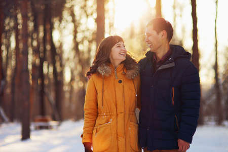 Warm winter portrait of young interracial smiling couple on a walk in the forestの写真素材