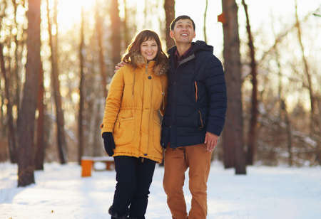 Warm winter portrait of a couple of different race in the forest.の写真素材