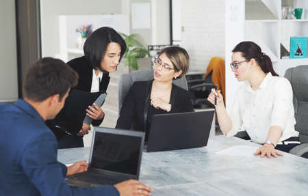 Three young successful business women in the office working together on a projectの写真素材