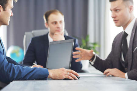 Three of young business man meeting in the office discussing an important idea togetherの写真素材