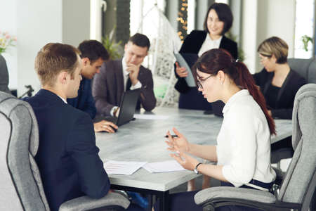 Group of young successful businessmen lawyers communicating together in a conference room while working on a project.の写真素材