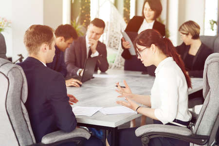 Group of young successful businessmen lawyers communicating together in a conference room while working on a project.の写真素材