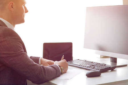 Young business man working at the computer and papers on the table.の写真素材