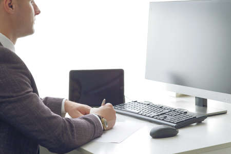 Young business man working at the computer and papers on the table.の写真素材