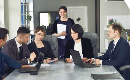 Group of young successful businessmen lawyers communicating together in a conference room while working on a project.の写真素材