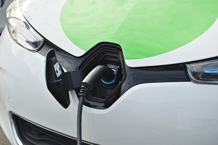 Close up power supply connected to electric car for add charge to the battery.