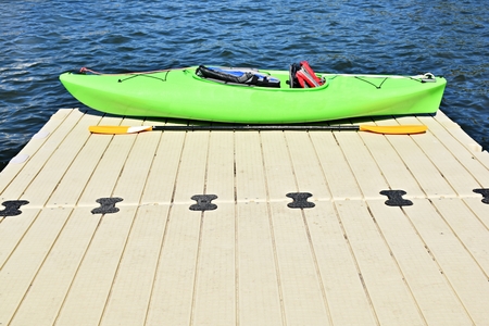 Kayak on wooden pier with blue sky background and no people