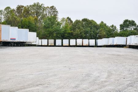 Parking lot of semi-trailers in a gravel parking lot