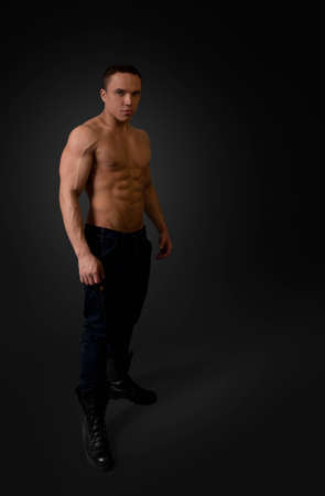 Sexy naked torso fit and neat young man studio full portrait  Wearing dark blue jeans and black boots  Fit and neat collection の写真素材