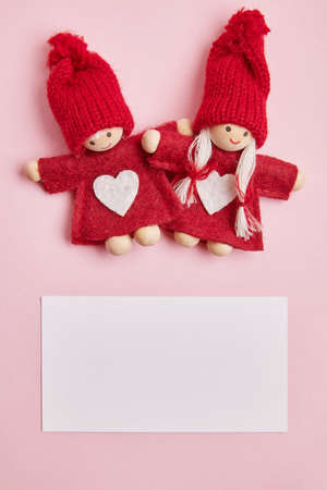 Toy midgets with greeting card on the rose backgroundの写真素材