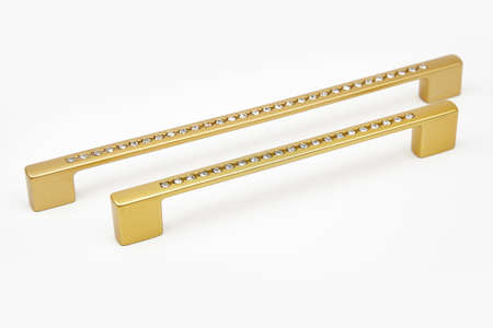 Gold metallic door handle with shiny transparent stones on white backgroundの写真素材