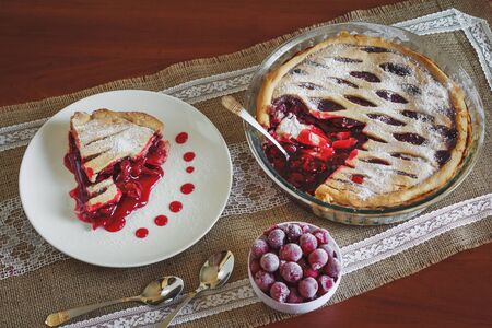 Slice of friut pie with cherries in white plateの写真素材