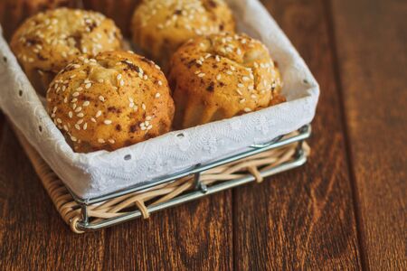 Light muffins with sesame on dark wooden backgroundの写真素材