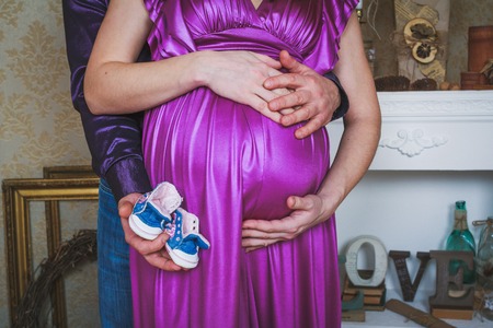 Pretty pregnant belly with baby bootsの写真素材
