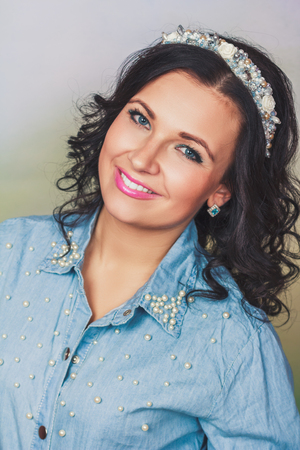 Attractive woman with coronet of beads in blue jeans shirtの写真素材