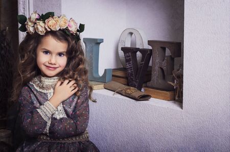 Small beautiful girl dressed in retro style with flower coronetの写真素材