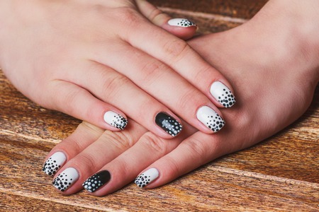 Black and white  nail art on dark wooden backgroundの写真素材