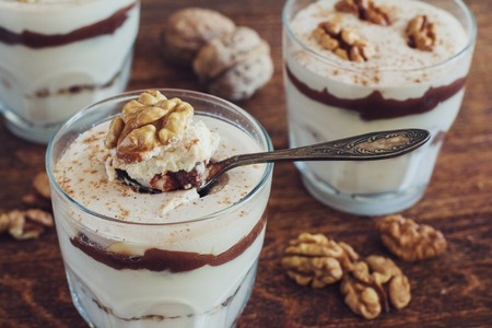 Homemade dessert with curd, walnut and chocolate on wooden tableの写真素材