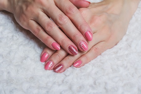 Pink nail art with flower on white textileの写真素材