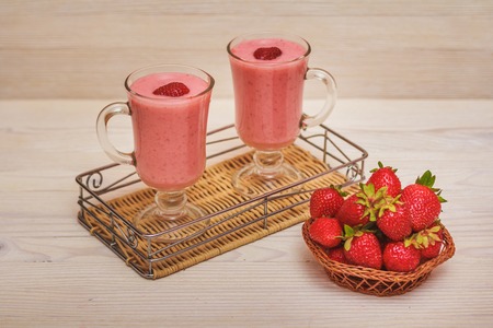 Strawberry smoothie in the glass on light  wooden backgroundの写真素材