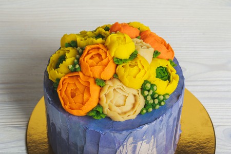 Purple cake with cream flowers on light backgroundの写真素材