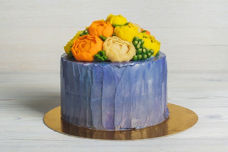 Purple cake with cream flowers on light backgroundの写真素材