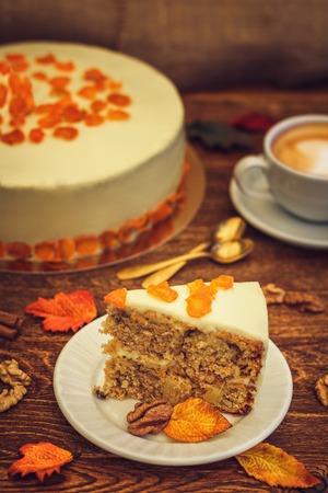 Carrot cake with cappuccino on brown wooden backgroundの写真素材