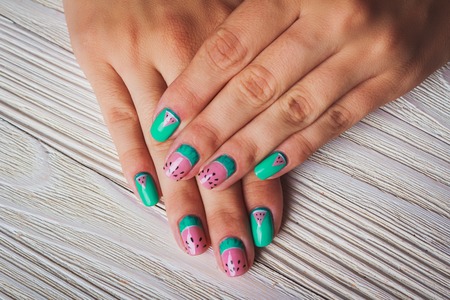 Summer watermelon nail design on wooden backgroundの写真素材