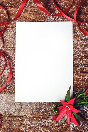 Christmas holiday background with red poinsettia flower decoration and ribbon with white blank for your textの写真素材