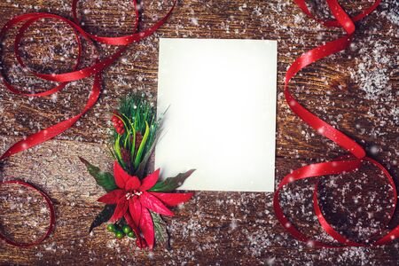 Christmas holiday background with red poinsettia flower decoration and ribbon with white blank for your textの写真素材