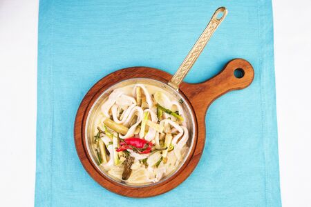 Mediterranean noodle soup with colmar rings, onions, cucumbers and hot peppersの写真素材