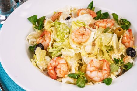 Mediterranean salad. Cabbage, shrimps and olives, seasoned with olive oilの写真素材