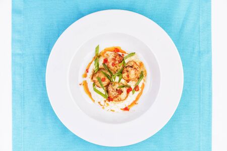 Pan-seared scallops on mashed potato with tomato sauceの写真素材