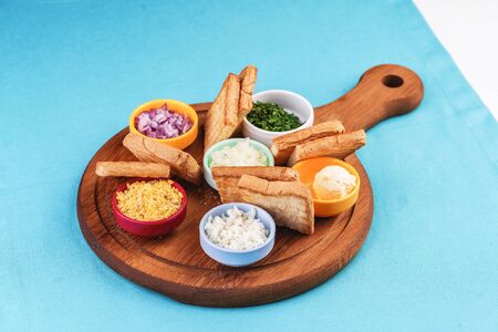 Mediterranean platter of onion rings, bread toasts and dip sauces