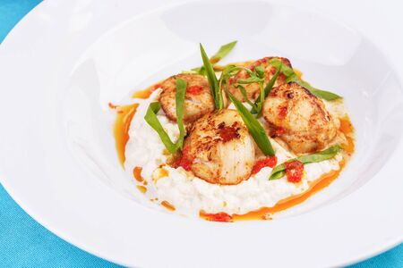Pan-seared scallops on mashed potato with tomato sauceの写真素材