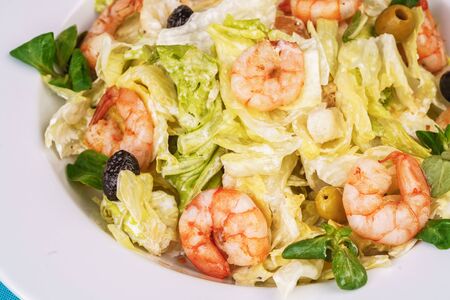 Mediterranean salad. Cabbage, shrimps and olives, seasoned with olive oilの写真素材