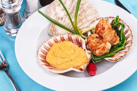 Pan seared scallops with pea puree, leek and red pepperの写真素材
