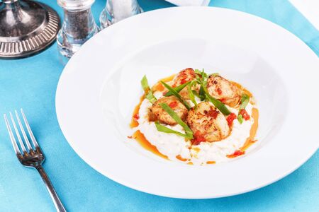 Pan-seared scallops on mashed potato with tomato sauceの写真素材