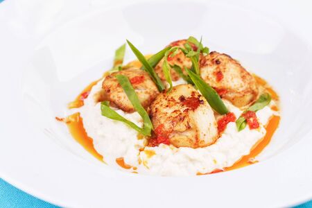 Pan-seared scallops on mashed potato with tomato sauceの写真素材