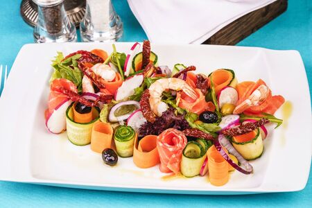 Mediterranean snack. Sliced radishes, shrimps, salmon, chili peppers and greensの写真素材