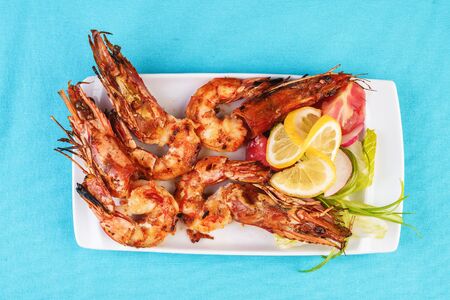 European cuisine, Mediterranean dish. Whole prawns fried in garlic oil with spices, beer snack with tomatoes, herbs and lemonの写真素材