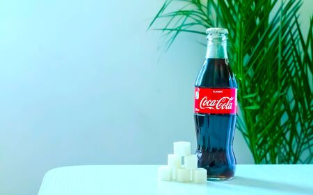 Kazakhstan Almaty, October 18, 2019. A bottle of Coca-Cola stands on a table with refined sugar...