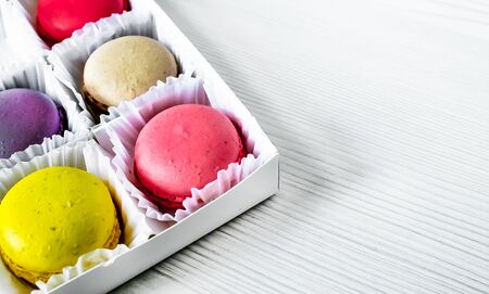 White pack with Macarons cookie, on a white wooden background. View from above. Copy spaceの写真素材