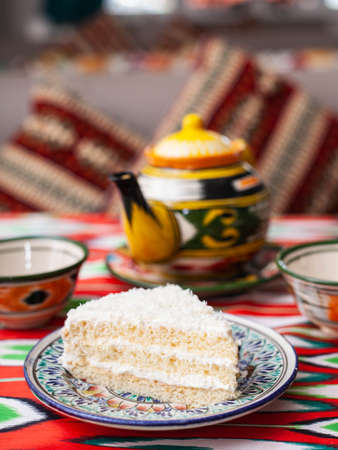 dessert milk girl with white cream and coconut in oriental style on a rooftop with a teapot and a cup for tea.の写真素材