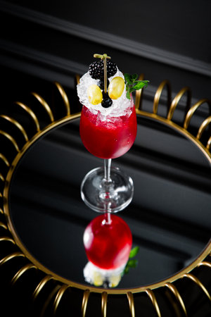 red cocktail on a dark background with whipped cream topping side viewの写真素材