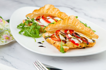 croissants with cheese, vegetables, cherry tomatoes and herbsの写真素材
