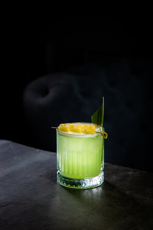 lime coctail with pineapple pieces and cinnamon side view