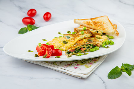 Breakfast of eggs and vegetables with cherry tomatoes and slices of bread in a white plate side viewの写真素材