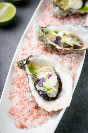 Grilled oysters on red sea salt with lime