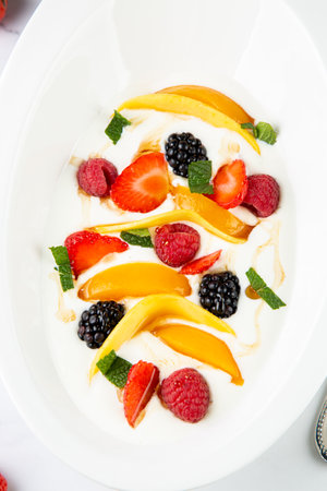 raspberry, peach, strawberry, black berry, strawberry and mint in whipped cream, side viewの写真素材